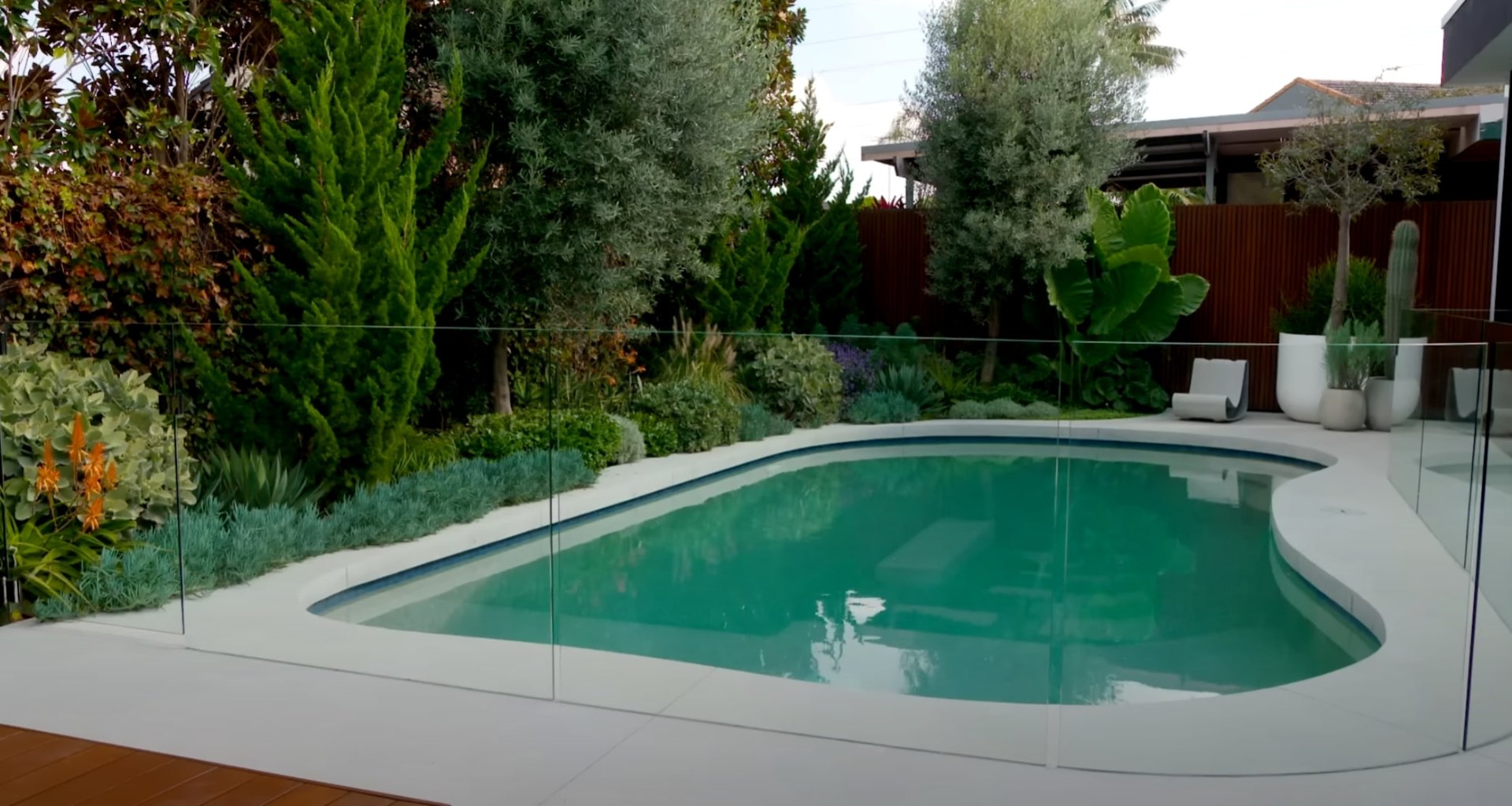 Modern backyard with swimming pool, outdoor seating area, and professional landscape design for entertaining