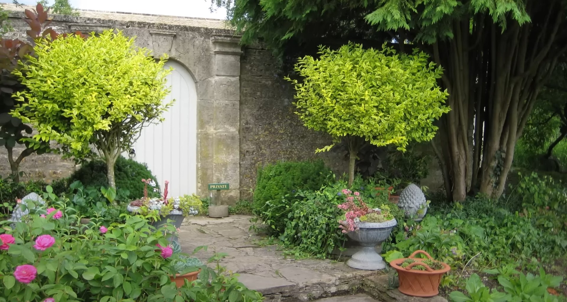 Professional Garden Design - Stone Archway and Lush Landscape Elegant garden entrance with stone archway, lush plantings, and professional landscape design