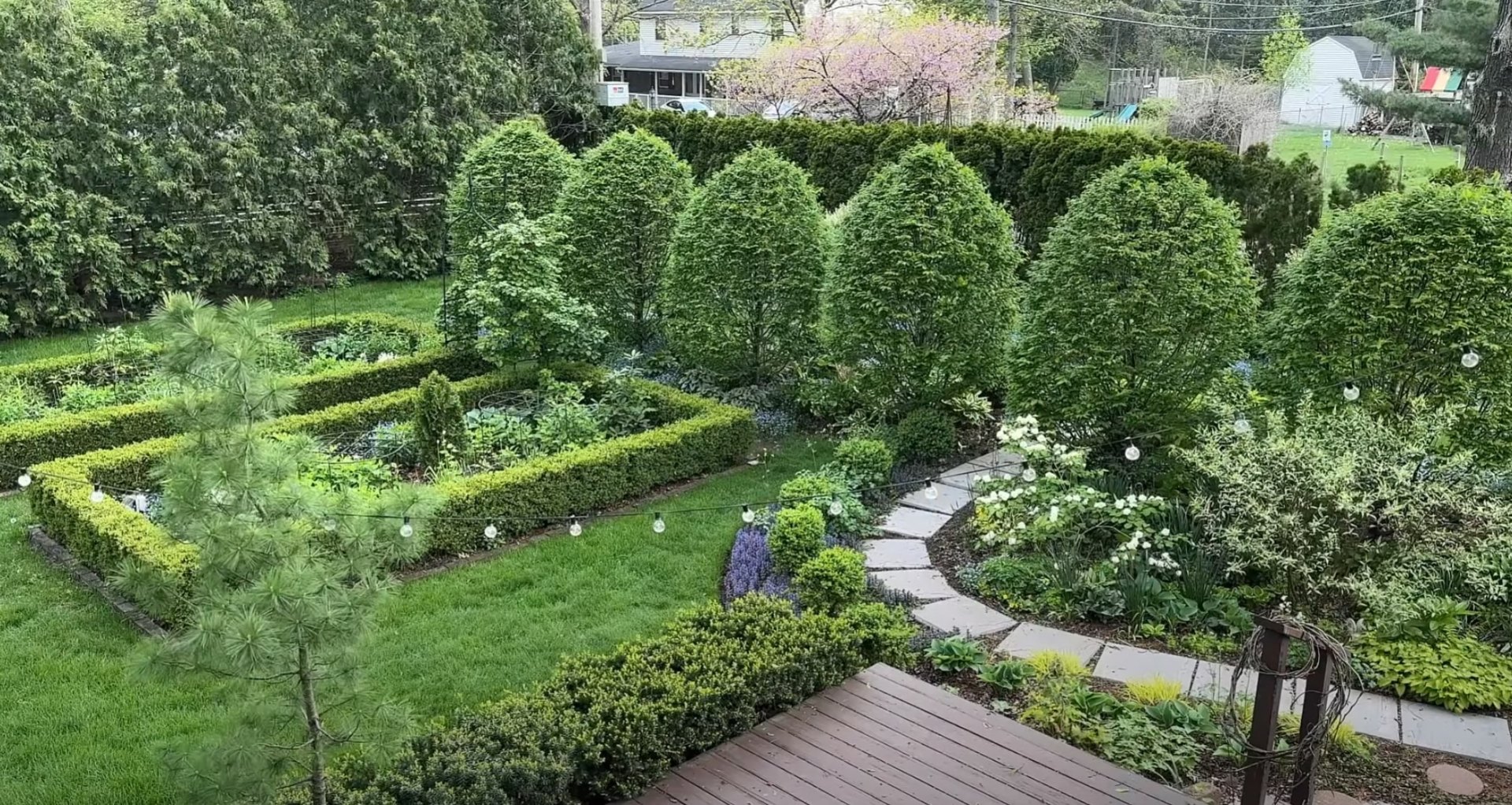 Formal garden design with geometric lawn patterns, hedged borders, and pathway lighting